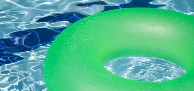 green pool float in crystal clear, blue water pool.