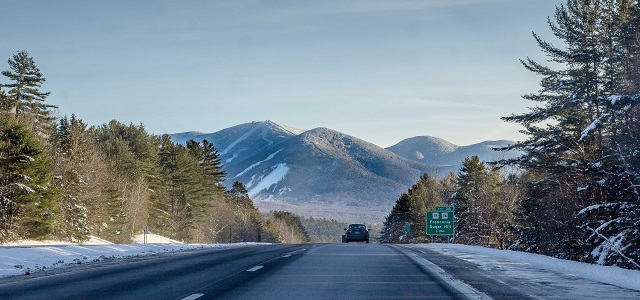 viewpoint from a car on a highway leading to franconia notch state park and a scenic mountain view.