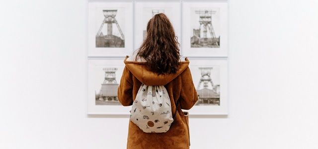 a woman observing a set of images in an art gallery.