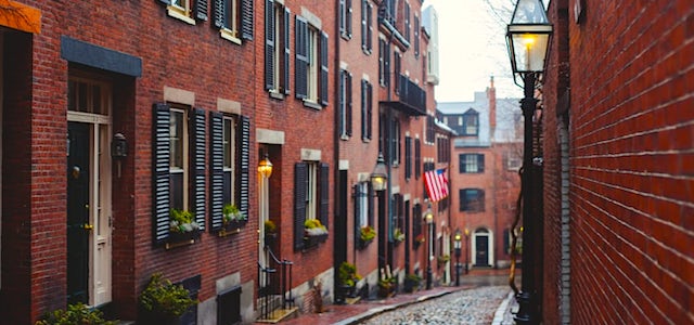 a sidewalk down a quiet boston street with brownstones on either side.