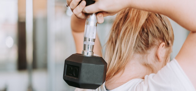 woman using a weight in the gym